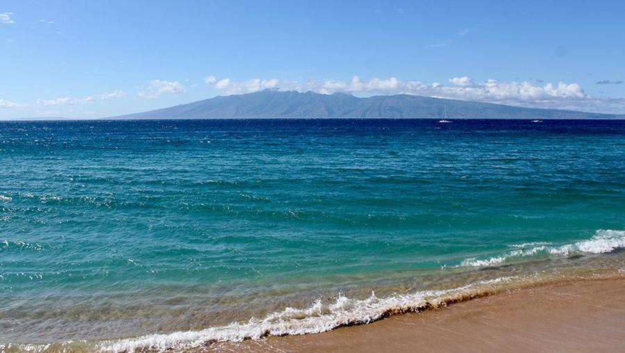 Bright and vibrant blue waters washing up on the shore of Kaanapali Beach in Maui.